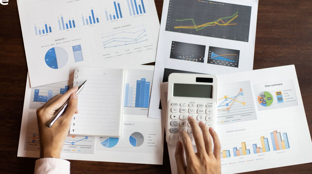 A finance executive is working on calculating budgets and spend for the month using a calculator.