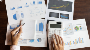 A finance executive is working on calculating budgets and spend for the month using a calculator.