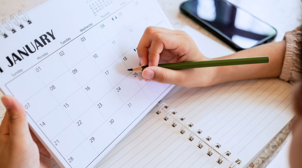 Title (24) A person is looking at a calendar for January, they are writing on a day to note it as a good time to upgrade your crm.